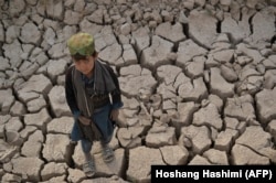 A child stands on land cracked by drought in the Bala Murghab district of Badghis Province in October.