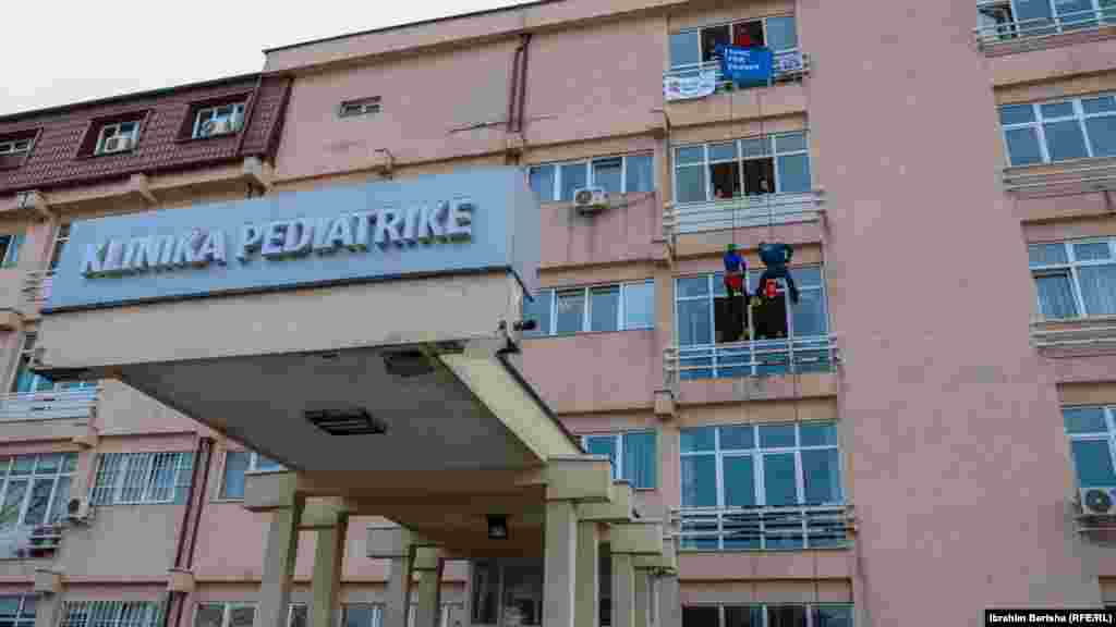Dva penjača obučena kao ljekari spuštaju se konopcima i zabavljaju djecu na Pedijatrijskoj klinici u Prištini.