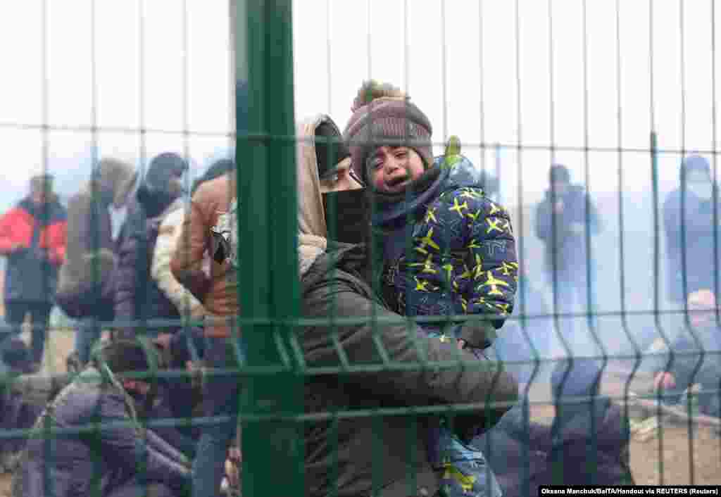 Egy apa és gyermeke a belarusz&ndash;lengyel határon, a Bruzgi&ndash;Kuźnica&nbsp;határátkelőnél