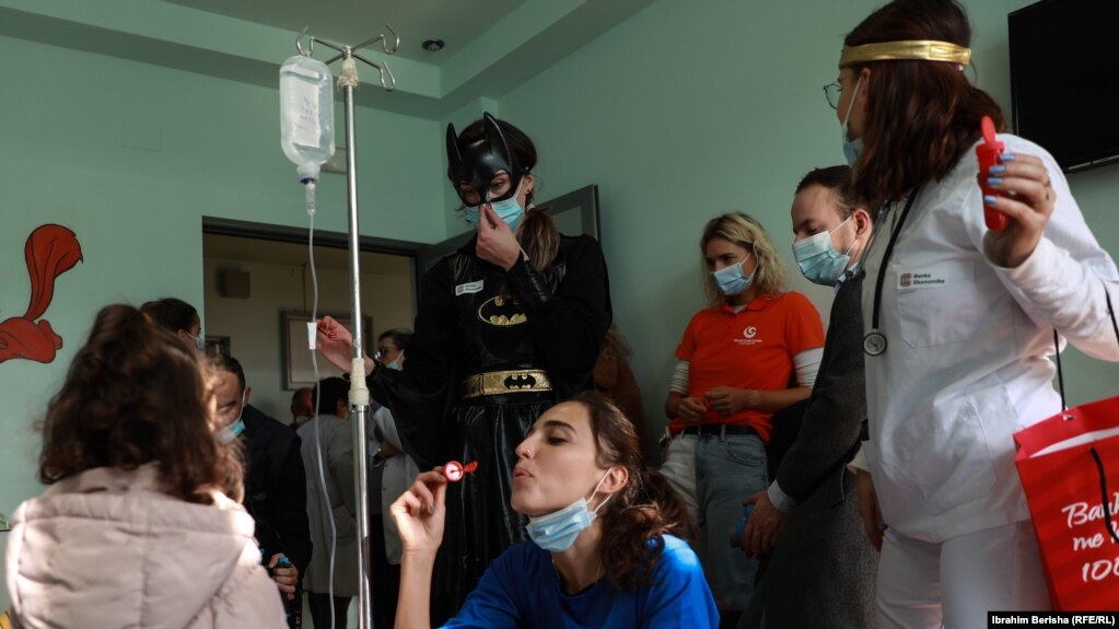 Disa aktivistë të veshur me rroba të ndryshme argëtojnë fëmijët e shtrirë në Klinikën e Pediatrisë në Prishtinë.