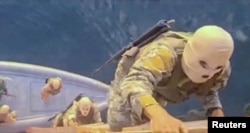 A screen grab of video broadcast on Iranian TV on April 22 purportedly shows soldiers taking part in the seizure of the container ships MSC-Francesca and Epaminondas in the Strait of Hormuz.
