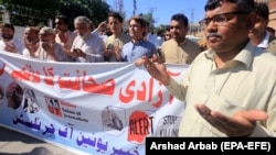 Pakistani journalists pray for those colleagues who were killed in the line of duty during a rally marking World Press Freedom Day in Peshawar on May 3.