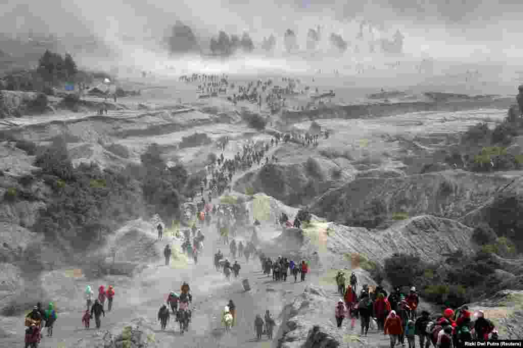 Tenggerese people and tourists gather near the Bromo volcano during the annual Kasada ceremony where Hindu worshipers throw offerings such as crops and livestock into the crater as thanksgivings to their gods, in Probolingg, Indonesia, on July 18. (Reuters/Rizki Dwi Putra)