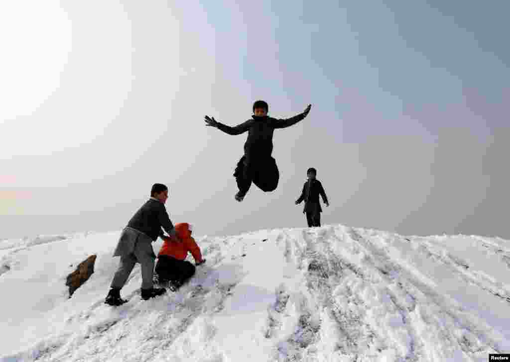 ავღანელი ბიჭები თოვლში თამაშობენ ქაბულის გაერუბანში. (REUTERS/Mohammad Ismail)