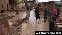 Afghans survey their damaged houses after seasonal floods in Herat on March 29.
