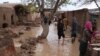 Afghan people survey their damaged houses after flooding in Herat on March 29.