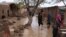 Afghan people survey their damaged houses after flooding in Herat on March 29.