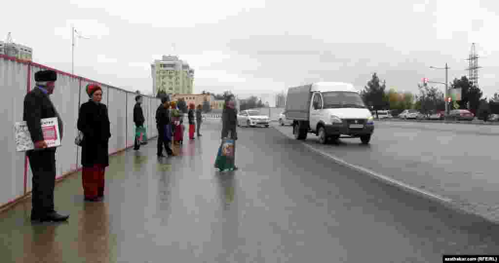 Aşgabadyň Andalyp köçesi bilen S.Nyýazow şaýolunyň çatrgynyda duralganyň göz öňünde tutulmadyk ýerinde awtobusa garaşýan ýolagçylar.