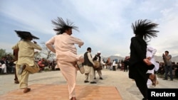 Afghan men perform the traditional "attan" dance in Kabul, April 17 2014.