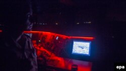 A Turkish coastal guard officer watches a monitor that shows a boat carrying Syrian refugees as they attempt to reach the Greek island of Chios in the Aegean Sea near Izmir in December.