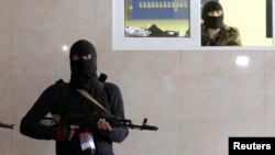 Вооруженный мужчина в маске в контролируемом пророссийскими сепаратистами Луганске. Апрель 2014 года.