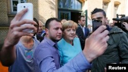 Angela Merkel okružena izbjeglicama