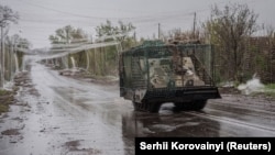 Військова машина їде дорогою, вкритою сіткою проти дронів, у Дружківці на Донеччині, 24 квітня 2026 року