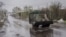 Військова машина їде дорогою, вкритою сіткою проти дронів, у Дружківці на Донеччині, 24 квітня 2026 року