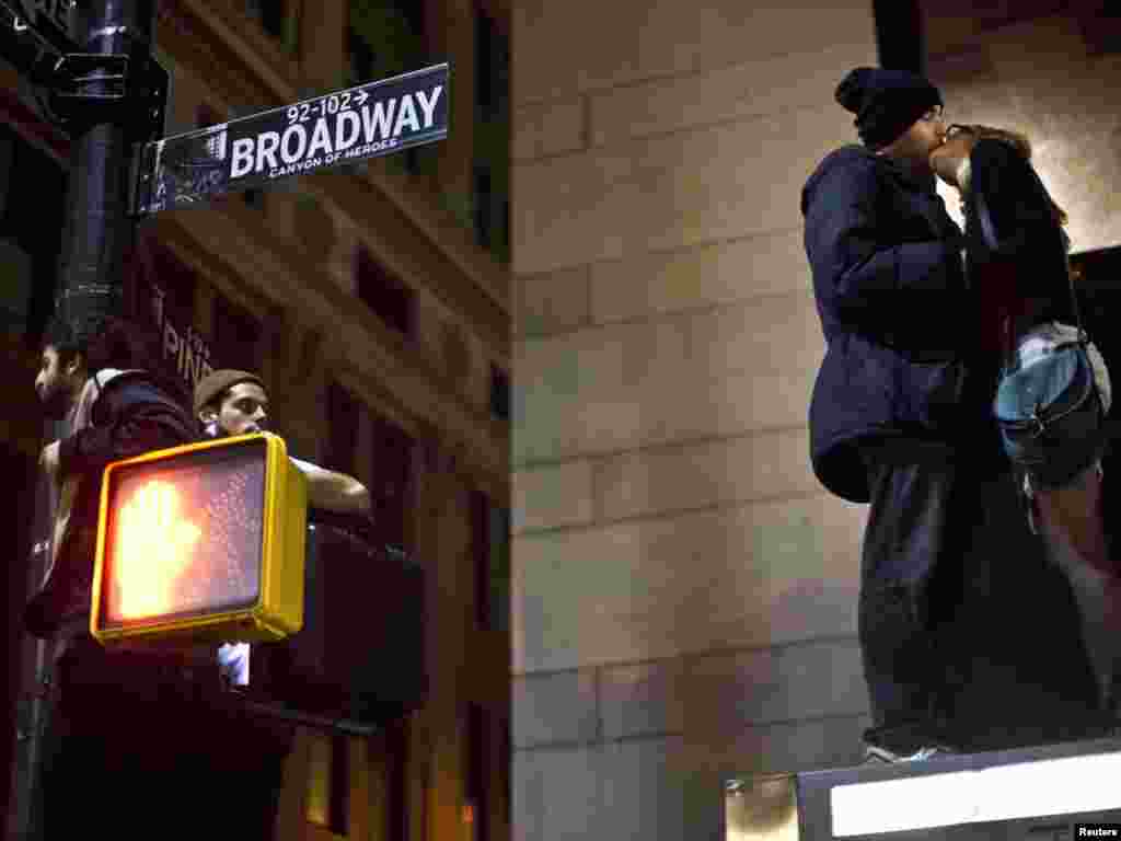 Protesters affiliated with the Occupy Wall Street movement kiss while standing atop a bus stop during an unannounced raid by the New York City Police Department outside Zuccotti Park in New York on November 15. (REUTERS/Andrew Burton)