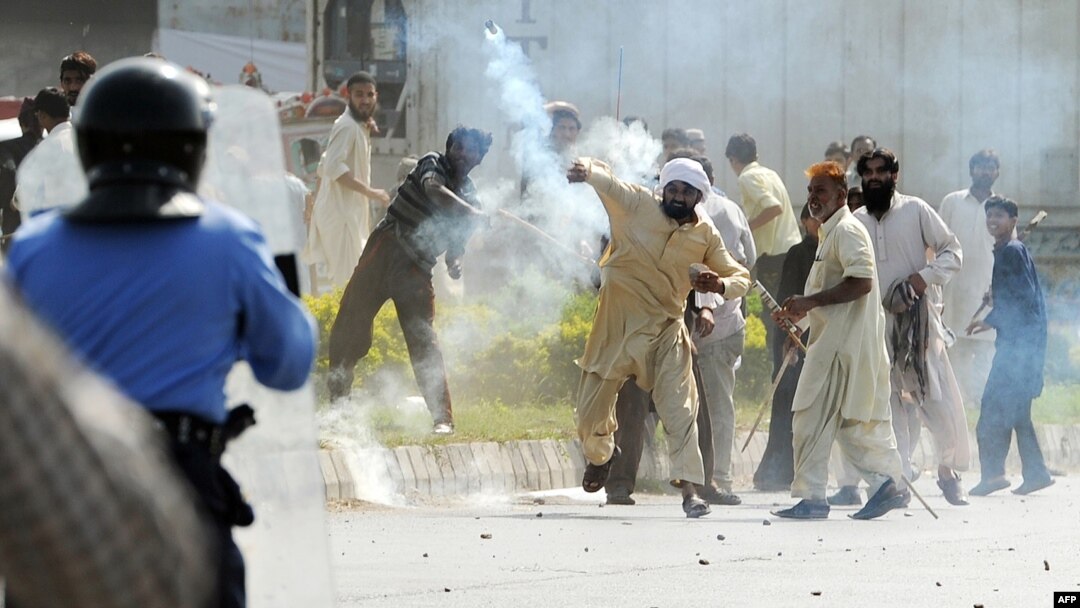 A demonstrator throws a tear gas shell toward Pakistani riot police during a protest against the film "Innocence of Muslims" in Islamabad.