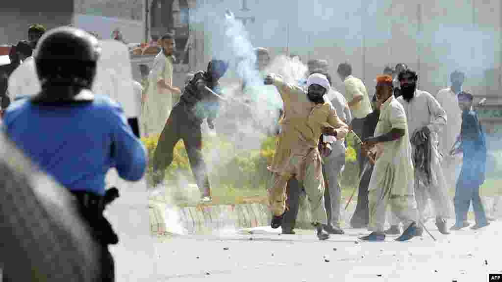 A demonstrator throws a tear-gas shell toward riot police during a protest against an anti-Islam film in Islamabad on September 21.