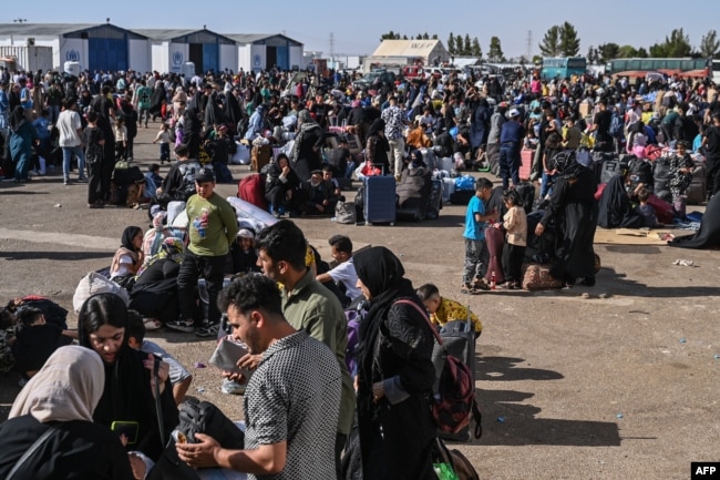 Refugjatët afganë janë fotografuar në pikën kufitare Islam Qala midis Afganistanit dhe Iranit më 28 qershor 2025, pas dëbimit nga Irani.