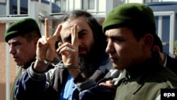 Язык жестов явно не выдает в препровождаемых в здание суда пособниках "Аль-Каиды" раскаявшихся людей