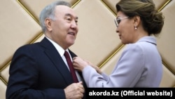 Дарига Назарбаева вручает своему отцу Нурсултану Назарбаеву нагрудный знак «Почетный сенатор». 6 июня 2019 года.