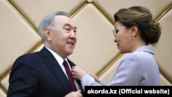 Спикер сената парламента Казахстана Дарига Назарбаева вручает знак «почетного сенатора» своему отцу, бывшему президенту Нурсултану Назарбаеву. Нур-Султан, 6 июня 2019 года.