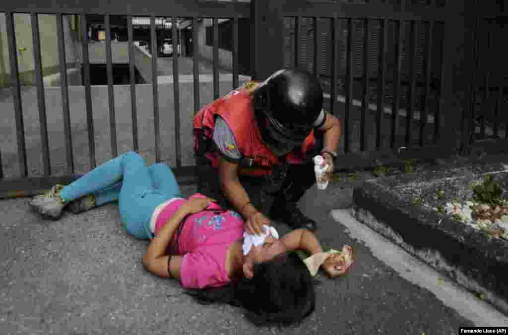 A paramedic helps a protester suffering from the effects of tear gas. 
