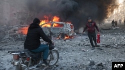 People try to extinguish fires following an air strike that targeted Syria's rebel-held northern city of Idlib on December 2. Since Russia intervened in the civil war in Syria, its aerial attacks have played a crucial role in propping up Syrian President Bashar al-Assad.