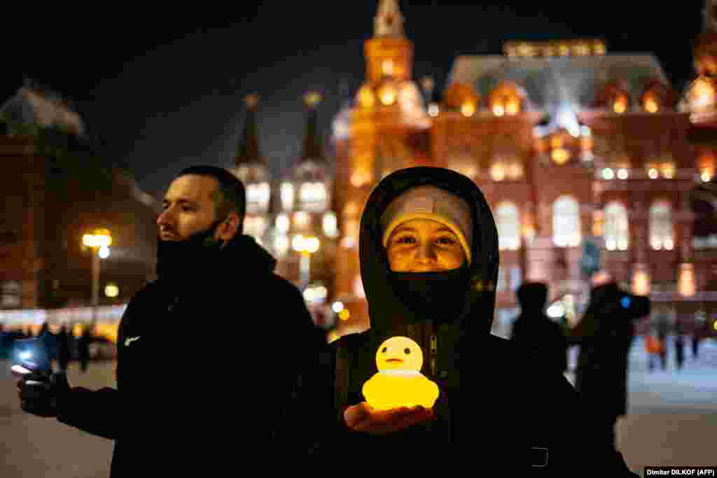 Жінка позує з пластиковим каченям, яке світиться, біля Червоної площі в Москві. Качка є натяком на те, що колишній прем&#39;єр-міністр (експрезидент на один термін) Дмитро Медведєв має розкішне майно зі приватним озером і притулком для водоплавних птахів