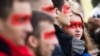 Учасники віча «Зупинимо капітуляцію!» із червоною лінією на обличчях під час здійснення «обходу» урядового кварталу. Київ, 6 жовтня 2019 року