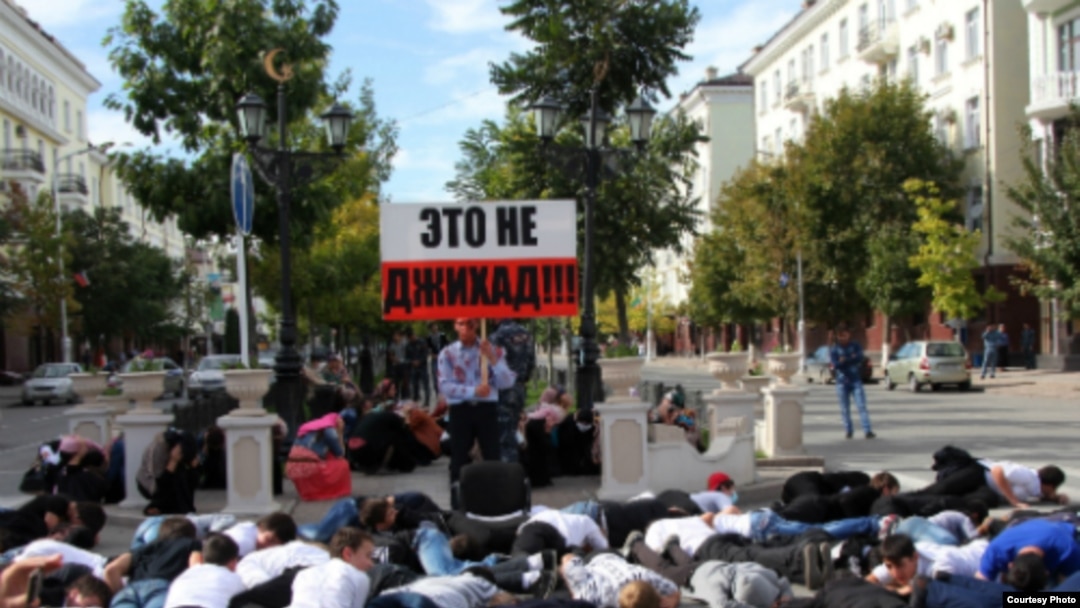 В центре массовки появился человек, одетый в черное и олицетворявший террориста-смертника. Раздался взрыв (петарды), и участники флешмоба рухнули на землю. Стоять остался только молодой человек с окровавленным лицом, в разодранной одежде с трафаретом в руках. Двусторонняя надпись гласила: "Убивать мирных людей – это не джихад!
