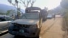 Vehicles drive past a damaged police vehicle that was escorting a convoy of foreign diplomats near Malam Jabba in Pakistan's Khyber Pakhtunkhwa Province on September 22.