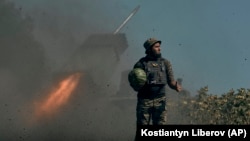 Український солдат на тлі реактивної системи залпового вогню в Донецькій області, 3 вересня 2022 року
