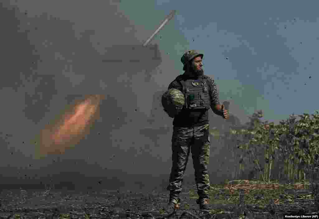Украинский солдат держит арбуз во время пуска ракеты по линии фронта в Донецкой области, 3 сентября 2022 года. Плод стал символом контрнаступательной операции украинской армии по освобождению города Херсона, оккупированного российскими войсками в марте.