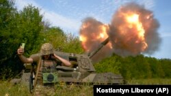 Український солдат робить селфі на тлі пострілу з артилерійської системи, Донецька область, вересень 2022 року
