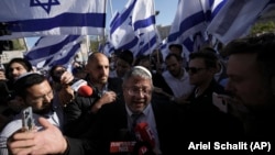 Izraelski zastupnik Itamar Ben-Gvir, okružen desničarskim aktivistima daje izjavu za medije prije marša u Jerusalemu, 20. aprila 2022. Nakon novembarskih parlamentarnih izbora, Ben-Gvirova stranka Vjerski cionizam, postala je treća najveća strankau Izraelu.