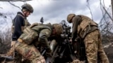 Ukrainian soldiers load a shell into howitzer before firing toward Russian positions in the Kharkiv region on March 12. 