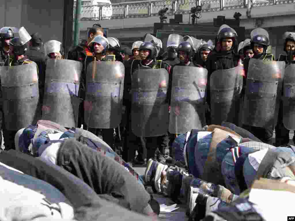 Demonstrators perform Friday Prayers in front of riot police during a demonstration in Cairo on January 28.