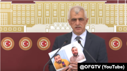 Türk syýasatçysy Ömer Faruk Gergerlioglu tussag edilen türkmen aktiwistleriniň suratyny görkezýär. 