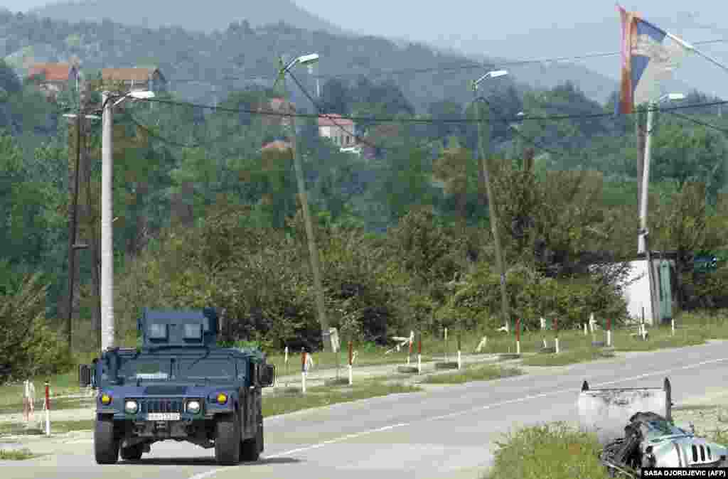 An armored Kosovar police vehicle drives near Leposavic in the north of Kosovo on September 1. Tensions flared over the license-plate requirement this summer after Pristina announced the rule would go into effect on September 1. After Serbs set up roadblocks, the United States and EU pressured Kurti to delay the move.
