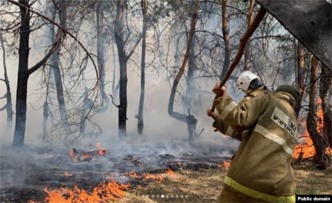 A firefighter works to prevent fire from spreading in Qostanai on September 4.