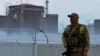  A serviceman with a Russian flag on his uniform stands guard near the Zaporizhzhia nuclear power plant in Ukraine. (file photo)