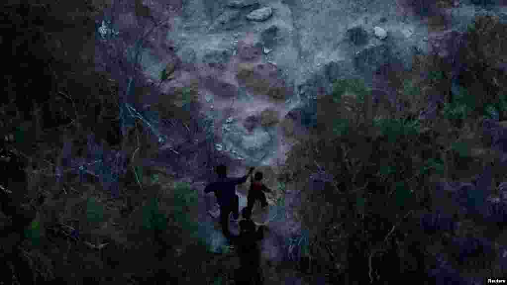 Migranti koji traže azil penju se na brdo dok prolaze migrantskom rutom nakon što su prokrijumčareni preko rijeke Rio Grande u Romu, Teksas, SAD, 27. august.