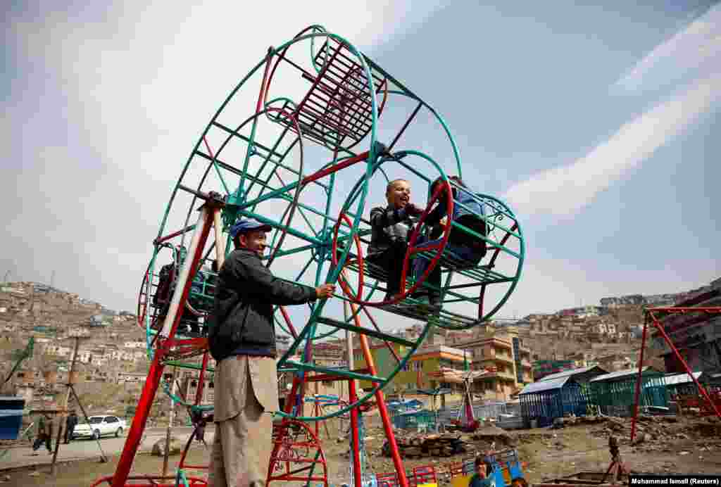 Children enjoy a manually operated Ferris wheel in Kabul. (Reuters/Mohammad Ismail)