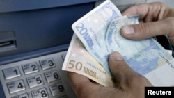 Arxiv fotosu: Yunanıstanda bankomatdan pul çıxaran vətəndaş. 