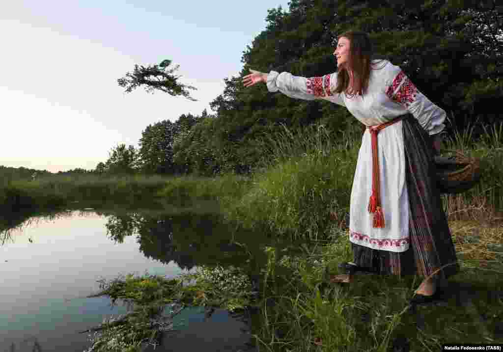 A girl throws a wreath of flowers into a river as part of a folk celebration in Belarus. (TASS/Natalia Fedosenko)