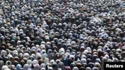 <p>Muslims attend Eid al-Fitr prayers to mark the end of the holy month of Ramadan, in Karachi, Pakistan, on March 31. 