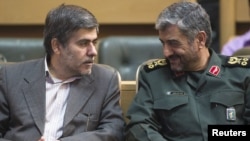 Revolutionary guards commander Mohammad Ali Jafari (R) speaks with Fereydoun Abbasi (L), head of the country's Atomic Energy Organization, in Tehran, September 2011.