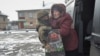 A Ukrainian police officer helps an elderly woman evacuate from the frontline town of Pokrovsk on February 7.