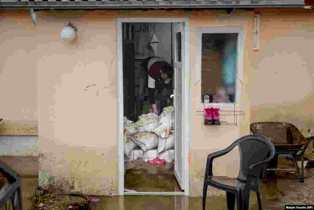 Meštanin pokušava da zaštiti deo unutrašnjosti kuće od poplava u Čačku, Srbija, 19. januar