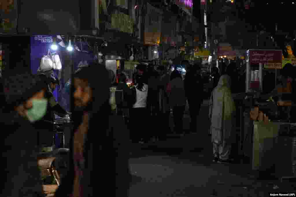 People visit a market in Islamabad where some shopkeepers were using generators for electricity. The outage was reminiscent of a massive blackout in January 2021, attributed at the time to a technical fault in Pakistan&#39;s power-generation and -distribution system.